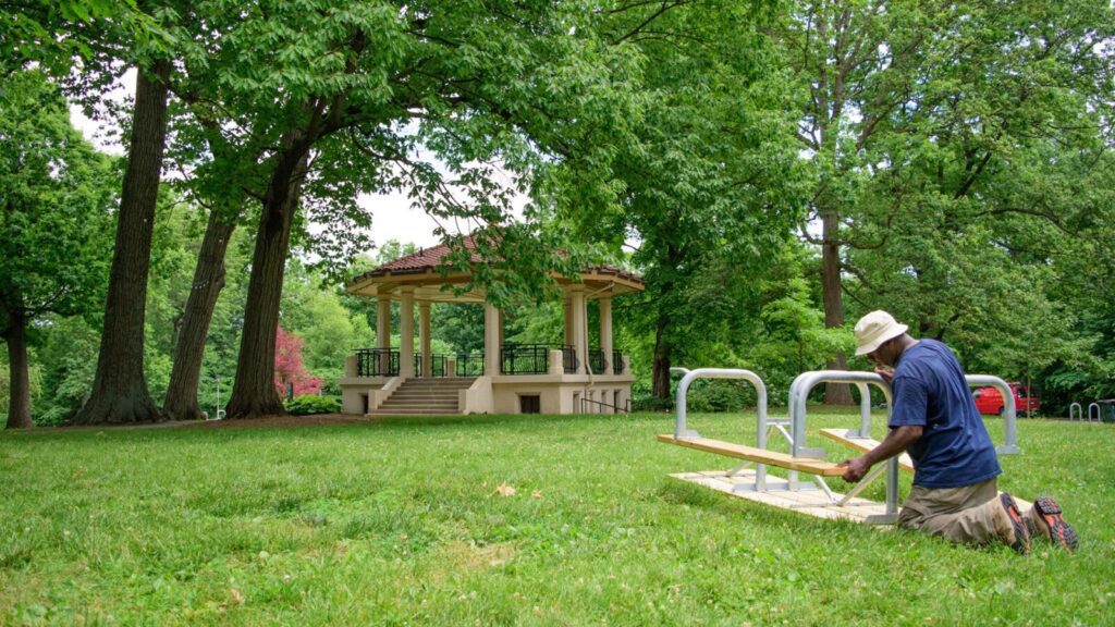 A man installing a picnic table in Burnet Woods