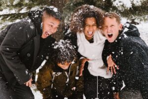 A family laughing in a snowball fight