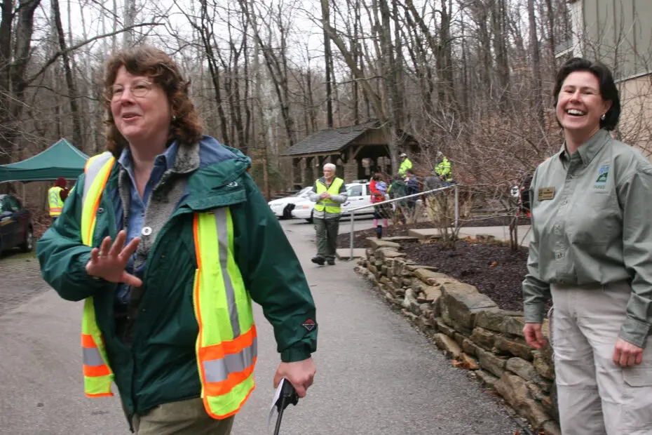 Erin Morris and naturalists smiling and directing traffic at an event