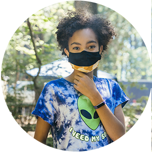 A girl in a face mask at summer camp