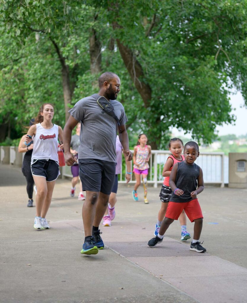 A team of athletes runs through Cincinnati Parks in the be.we;; program