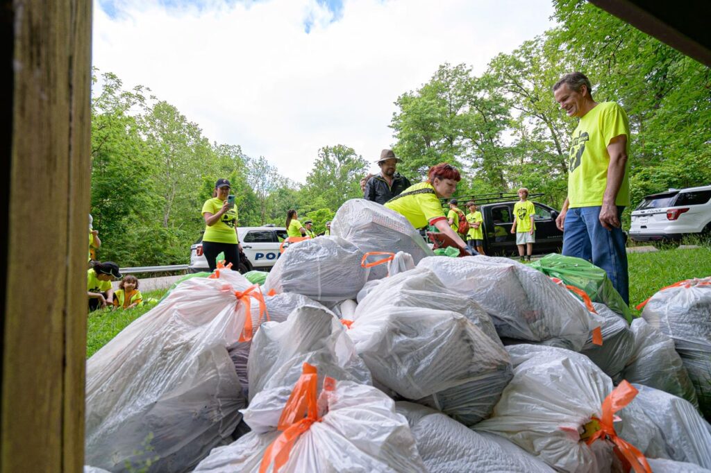 Piles of litter in trash bags by the Mt. Airy Sign