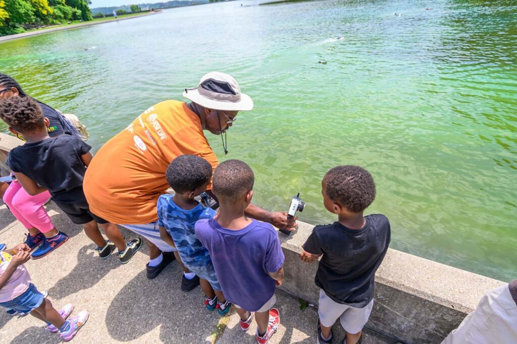 Stephan Pryor teaching children how to use RC boats in Eden Park