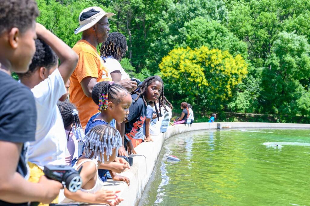 Children overlooking the Reach a Youth Teach a Youth RC boats in Eden Park