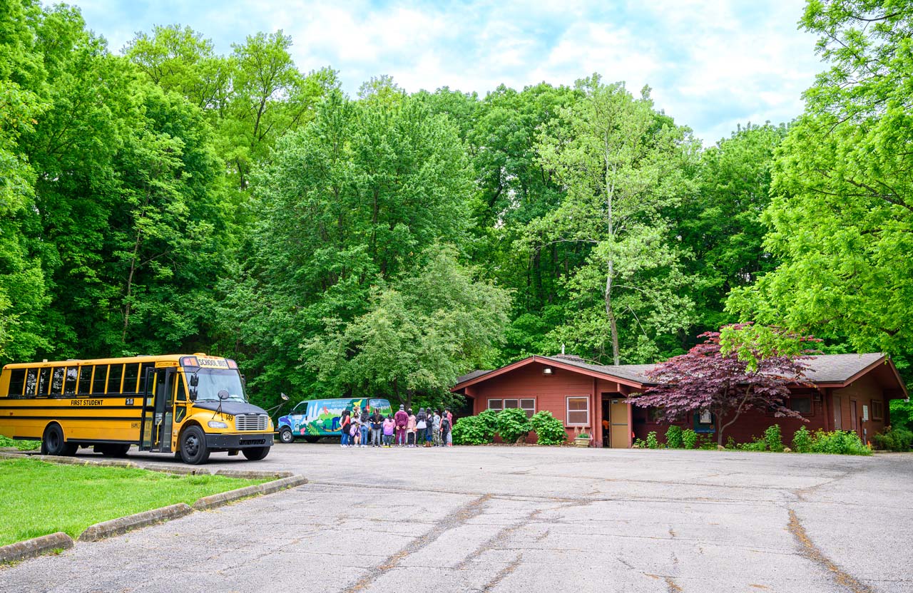 A group of children and a bus at a Cincinnati Parks Explore Nature center