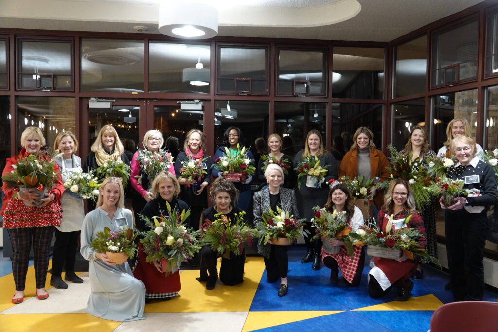 A group of women holding flower arrangements that they created