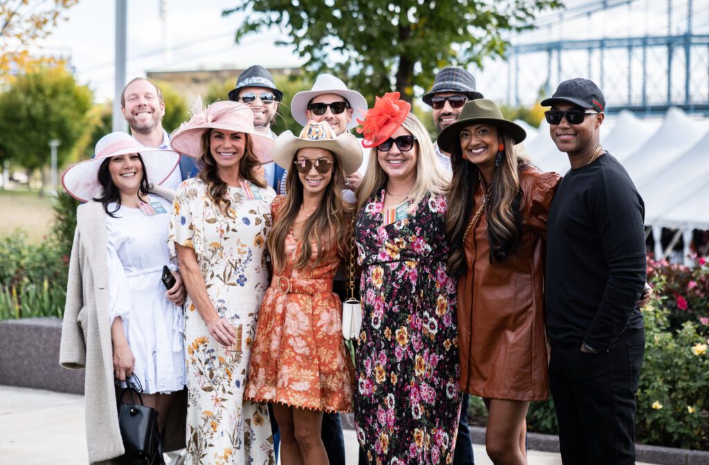 A group of smiling people wearing hats in a park