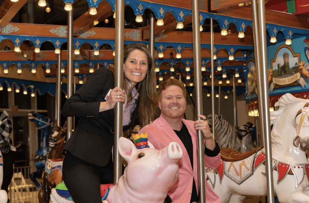 A woman and a man riding on a carousel,