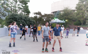 A group of peope roller skating in a big outdor space
