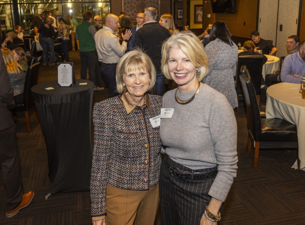 Carrie Hayden standing next to Cathy Crain. They are smiling and look at the camera.